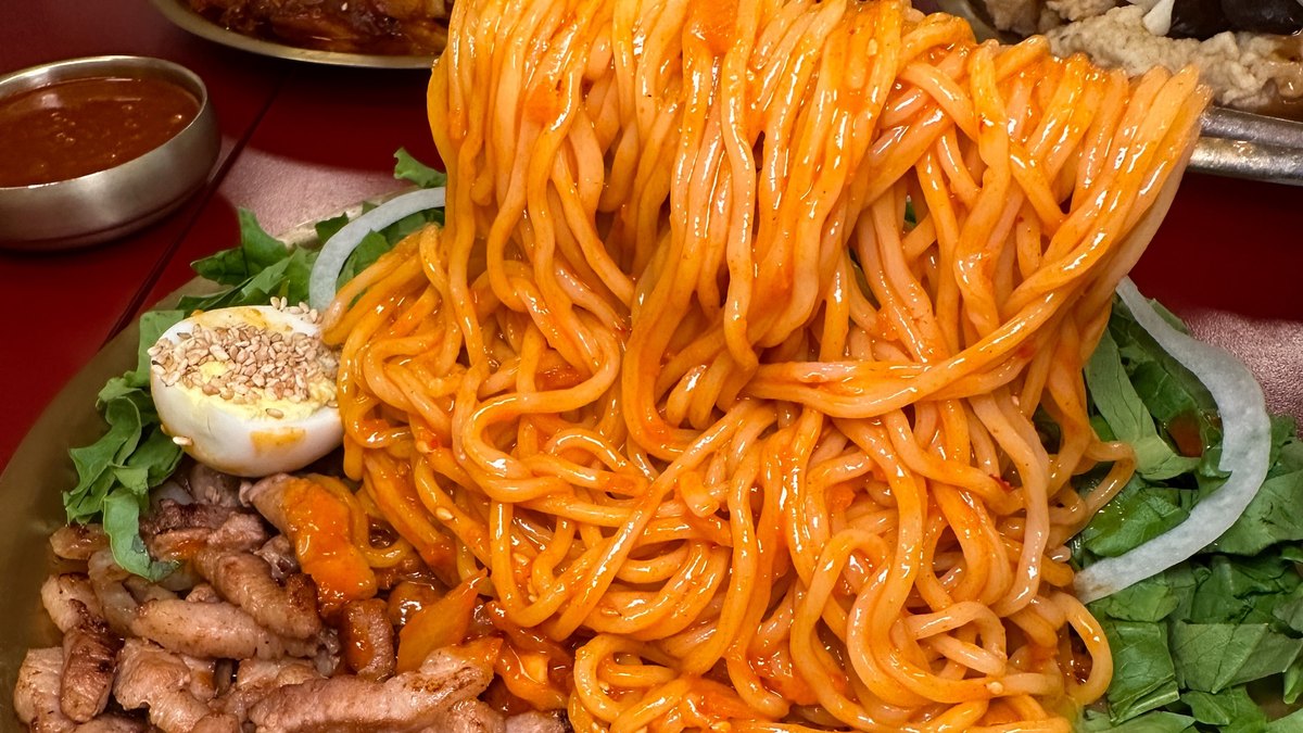 면을 높이 들어 올린 호랭이 곳간 직화구이 비빔면